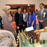 Akie Abe (center), visits the Tunisian booth as Tunisian Ambassador Farhad Khlif (right), and his wife, Mounira (second from right) explain the products. | YOSHIAKI MIURA