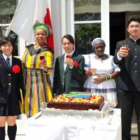 South African Ambassador Mohau Pheko (second from left), Minister Plenipotentiary Nosicelo Mbele (second from right) share a toast with three high school essay contest winners (from left) Karin Hiramatsu, Kyoko Ishiguro and Hikaru Ito, during a reception to celebrate the country’s National Day at the official residence in Tokyo on April 27. | YOSHIAKI MIURA