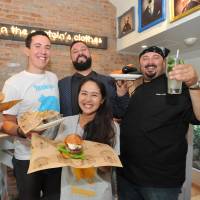 New York-based Bareburger Group CEO Euripides Pelekanos (second from right) and CBO John Simeonidis Jr. (left) poses with Natsumi Otsuka, manager of Bareburger in Japan (front), on Wednesday in its outlet in Tokyo. New York's Bareburger opens organic outlet in Tokyo