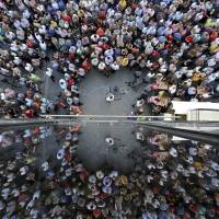 Greeks taking part in a pro-EU rally in Iraklio on Crete are reflected on a building\'s windows Thursday. | REUTERS