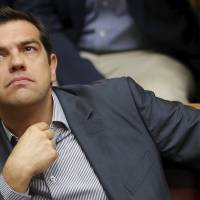 Greek Prime Minister Alexis Tsipras reacts during a voting session in parliament in Athens on Saturday. Greek lawmakers back bailout reform plan