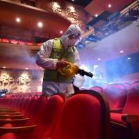 South Korean workers wearing protective gear fumigate a theater at the Sejong Culture Center in Seoul last month during an outbreak of Middle East respiratory syndrome (MERS) that triggered widespread panic and stymied growth in Asia’s fourth-largest economy. | AFP-JIJI