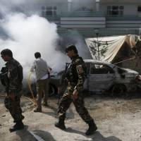 Afghan security forces walk past a burning car after a group of insurgents stormed a compound used by Afghanistan’s intelligence agency in Kabul Tuesday. Taliban insurgents raided the compound, a police spokesman said, killing one security guard and wounding another. The Taliban and Afghan government are reportedly holding direct talks in Pakistan to reach a breakthrough in their strife. Afghan regime holds first direct talks in Islamabad with Taliban; White House upbeat