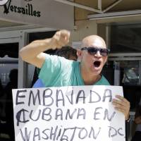 Anti-Castro activist Osvaldo Hernandez shouts anti-Obama slogans as he condemns the announcement of embassies in Washington and Havana Wednesday in the Little Havana area of Miami. | AP