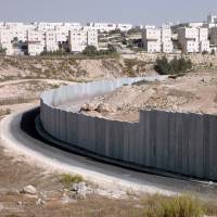 The Jewish neighborhood of Pisagat Ze\'ev in Jerusalem sits beyond the West Bank barrier that divides it from Shuafat, a Palestinian refugee camp, in October 2007. | BLOOMBERG