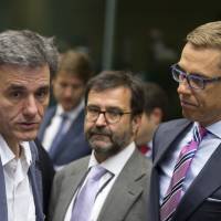 Finnish Finance Minister Alexander Stubb (right) speaks with Greek Finance Minister Euclid Tsakalotos during a roundtable meeting of eurozone finance ministers at the EU Lex building in Brussels on Sunday. | AP