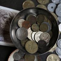 Drachma notes and coins, Greece’s national currency before adopting the euro, are displayed for sale at an Athens street market in June. How Greece might switch back to the drachma