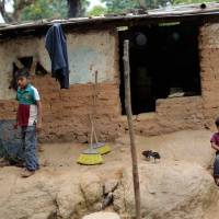 Children stay in front of their humble home in El Magueyito, Guerrero State, Mexico, on July 19. Poverty in Mexico has increased on the beginning of the presidential term of Enrique Pena Nieto with 2 million Mexicans joining this situation between 2012 and 2014, according to an official report released Thursday. | AFP-JIJI