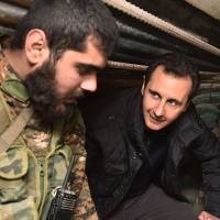 Syrian President Bashar al-Assad speaks with troops during a visit to the eastern Damascus district of Jobar on Dec. 31. | AFP-JIJI
