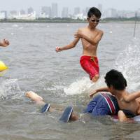Children play at the beach of Kasai Rinkai Park on Saturday in Tokyo\'s Edogawa Ward. | KYODO