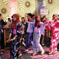 Foreign students in yukata summer kimono perform the traditional Bon dance Friday evening during a summer festival in Shibuya Ward, Tokyo. | YOSHIAKI MIURA