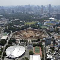 The construction site for the new National Stadium, which will replace Tokyo\'s National Olympic Stadium (center), as seen in June. | BLOOMBERG