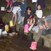 Participants in Potsdam, Germany, on Saturday recall the victims of the U.S. atomic bombings of Hiroshima and Nagasaki almost 70 years ago. They launched paper lanterns onto water. | KYODO