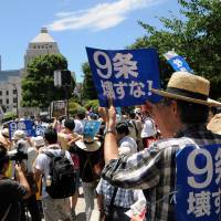 People rally in front of the Diet on Wednesday, as the ruling bloc bulldozed security bills through at a special committee of the Lower House. | SATOKO KAWASAKI
