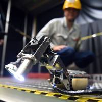 A Toshiba engineer watches a small robot with two CCD cameras, developed by Toshiba Corp. and the International Research Institute for Nuclear Decommissioning, in a demonstration at a Toshiba factory in Yokohama on Tuesday. Toshiba rolls out 'scorpion' robot to look inside crippled reactor at Fukushima No. 1