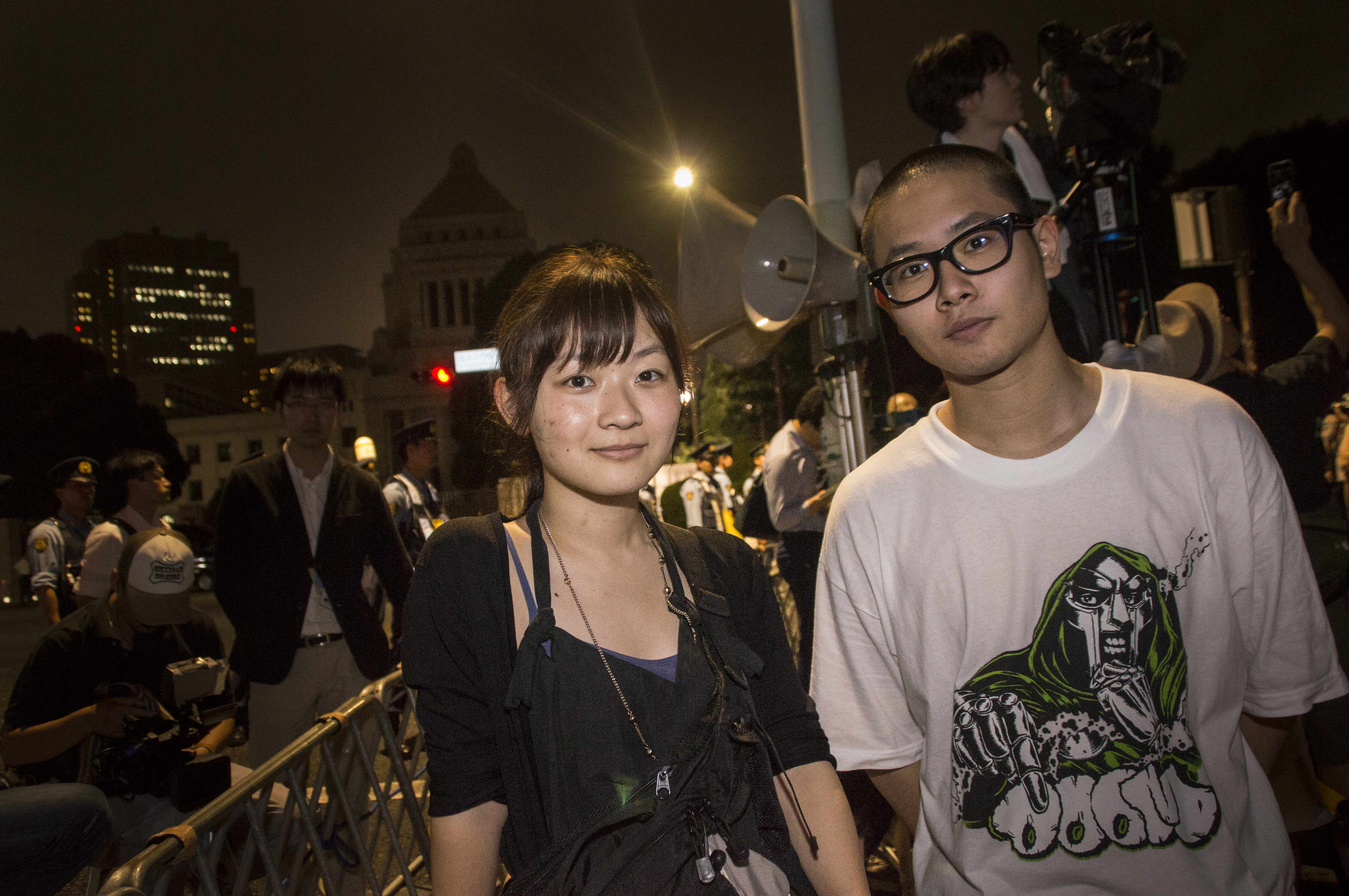 Touri Ise (left), head of the design team for the pro-democracy youth group SEALDs, and fellow member Yoshimasa Ushida pose for a photo during a recent protest over the security bills in front of the Diet. | CHIAKI UEDA
