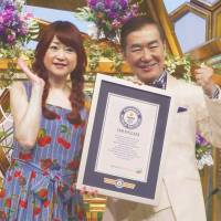 Katsura Bunshi, host of the \"Shinkon-san Irasshai!\" (\"Welcome, Newlyweds!\") talk show, and co-hostess Mami Yamase on Thursday pose in Osaka with a Guinness World Records certificate recognizing the program as the longest-running TV talk show hosted by the same presenter. | KYODO