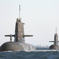 In this handout photo taken in March 2013, Royal Australian Navy submarines (from left) HMAS Dechaineux, HMAS Waller and HMAS Sheean leave in formation from the Royal Australian Navy’s HMAS Stirling base near the west coast city of Perth. | AUSTRALIAN DEFENSE FORCE/REUTERS