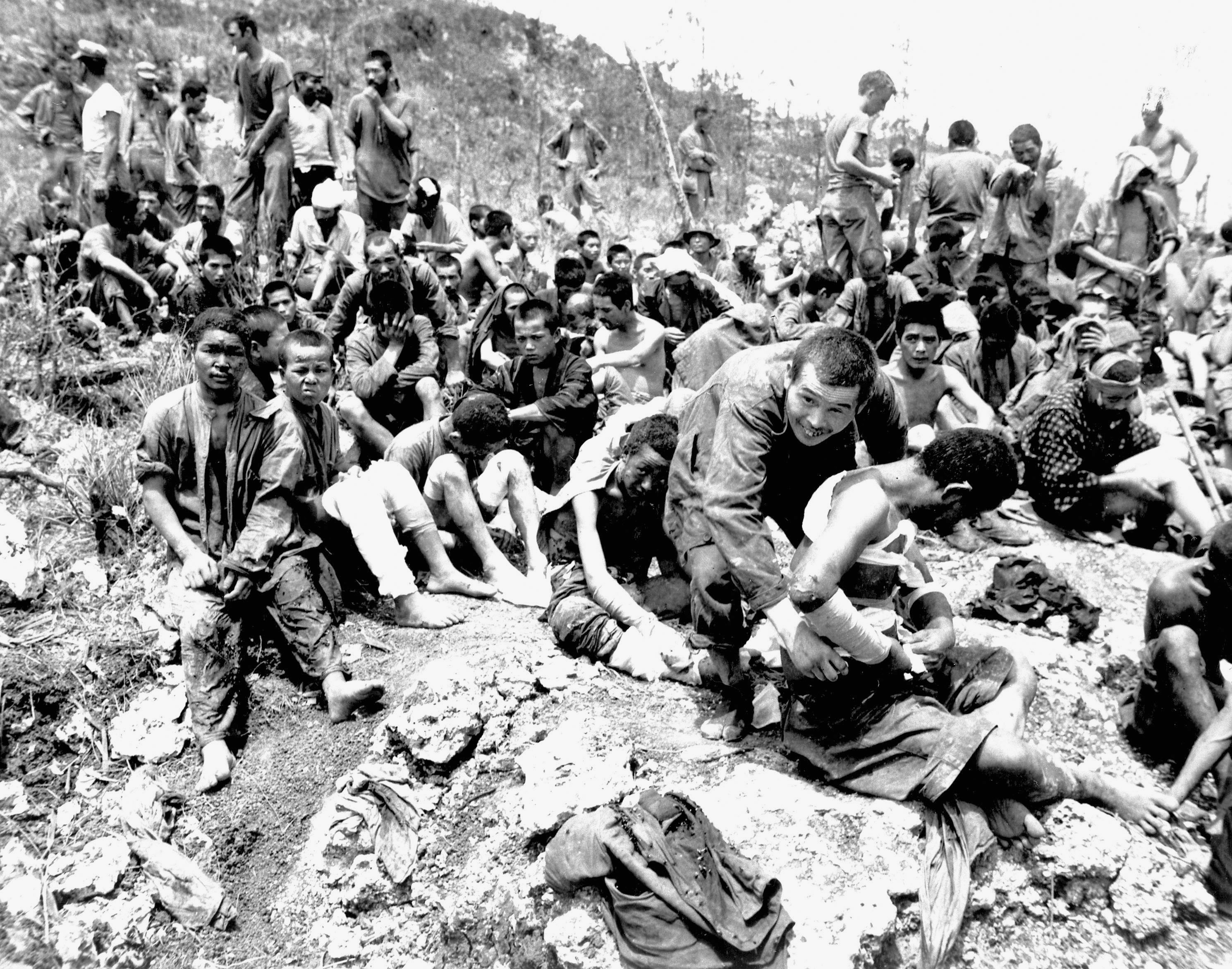 Okinawa residents, many of them wounded, surrender in June 1945 in this image taken by the U.S. military. | COURTESY OF OKINAWA PREFECTURAL ARCHIVES / KYODO