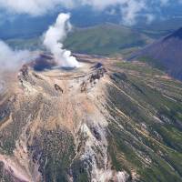 Smoke spews from the top of Mount Meakandake in eastern Hokkaido on June 29. The volcanic threat level was raised Tuesday out of fear of a small eruption. | KYODO