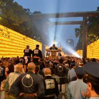 A portable shrine is carried past rows of lanterns during the Mitama Matsuri festival at Tokyo\'s Yasukuni Shrine in July 2013. | AFP-JIJI