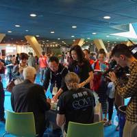 Surprise hit: \"The Cove\" authors Ric O\'Barry (seated left) and Hans Roth sign books at he Hangzhou Book Fair in April. | SASHA ABDOLMAJID