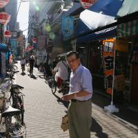 Yukio Shimada, owner of senbei shop Kisaku,  shows the way in Bunkyo Ward. | KIT NAGAMURA