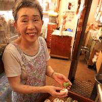 Keiko Uchida, owner of the traditional cake shop Asadaya, prepares traditional bean cakes. | KIT NAGAMURA