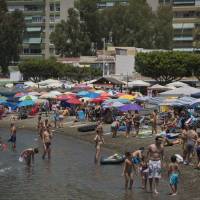 Hot stuff: Beachgoers relax on El Palo Beach in Malaga, Spain, on July 5. | AFP-JIJI