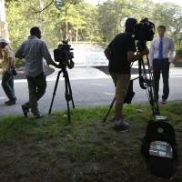 Members of the media stand along a road Tuesday near a residence of New England Patriots football quarterback Tom Brady, in Brookline, Massachusetts. Brady\'s four-game suspension for his role in using underinflated footballs during the AFC championship game has been upheld by NFL Commissioner Roger Goodell. | AP