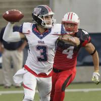 Japan\'s Toru Hirasawa (4) chases U.S. quarterback Dylan Favre, nephew of former NFL star quarterback Brett Favre, during the world championship final on Saturday. | USA FOOTBALL/ED HALL JR