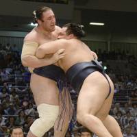 Kakuryu (right) overpowers Tochinoshin on Wednesday at the Nagoya Grand Sumo Tournament. | KYODO
