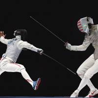 Yuki Ota (left) lunges at Alexander Massialas of the United States in the men\'s foil final at the World Fencing Championships on Thursday in Moscow. Ota, a native of Shiga Prefecture, defeated Massialas 15-10 to capture the gold medal, giving Japan its first-ever title at the sport\'s world championships. | REUTERS