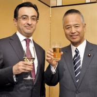 Azerbaijan Ambassador Gursel Ismayilzada (left) welcomes, Akira Amari, chairman of the Japan-Azerbaijan Parliamentary Friendship League, minister in charge of economic revitalization and state minister for economic and fiscal policy, during a reception to celebrate the country\'s Republic Day at the Okura Hotel on May 27. | YOSHIAKI MIURA