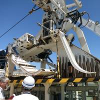 Equipment is loaded on to NTT World Engineering Marine Corp.’s ship Subaru at Yokohama port Thursday. | KAZUAKI NAGATA