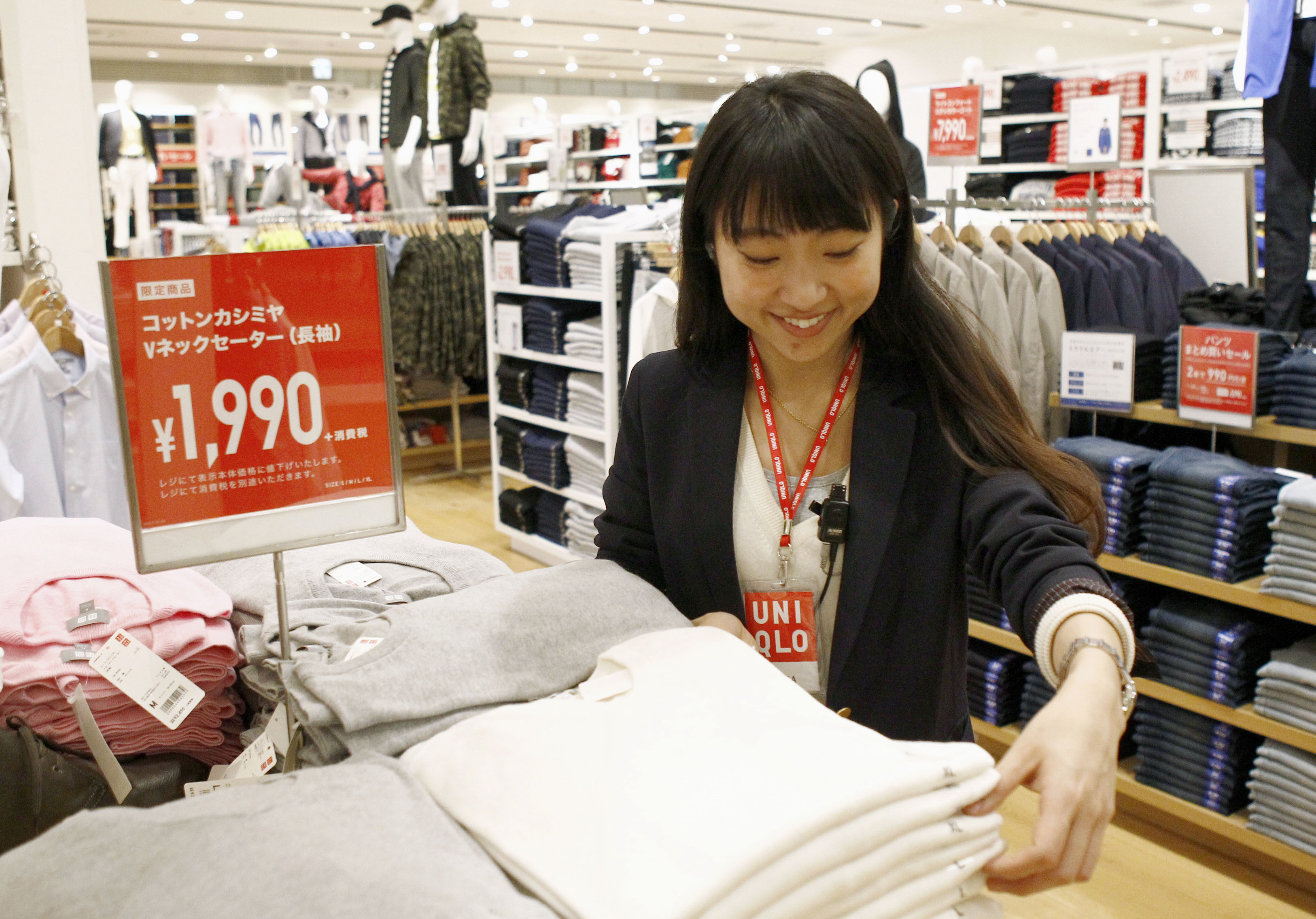 A worker seen at a Uniqlo store in Tokyo. Starting in October, full-time employees at Fast Retailing Co.'s stores can choose to work four days a week. | KYODO