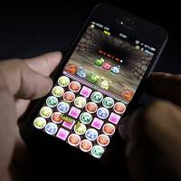The \"Puzzle &amp; Dragons\" smartphone game, developed by GungHo Online Entertainment Inc., is displayed on an Apple iPhone 5 smartphone in Tokyo on Aug. 10. | BLOOMBERG
