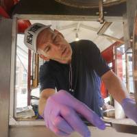 Mark Flannigan makes a batch of popcorn June 19 at the Popcorn Wagon in Pittsfield, Massachusetts. The latest Associated Press survey of leading economists, published Monday, shows that most economists predict tepid economic growth, weak pay gains and modest hiring for the next two years, at least. Analysts paint dimmer outlook for U.S. economy, wages, jobs: survey