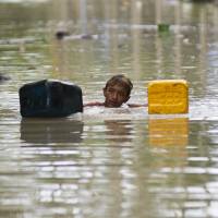A flood-affected resident swims through floodwaters in Kalay, upper Myanmar\'s Sagaing region on Monday.  | AFP-JIJI