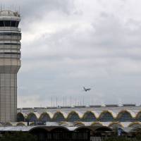 An airplane flies between the air traffic control tower and the Washington Monument at Washington’s Ronald Reagan National Airport, Monday. For more than three years, the government has kept secret a study it requested that found air traffic controllers’ work schedules often lead to chronic fatigue, making them less alert and endangering the safety of the national air traffic system, according to report on the study obtained by The Associated Press. U.S. air traffic controllers suffer chronic fatigue, 2011 study kept secret by FAA shows