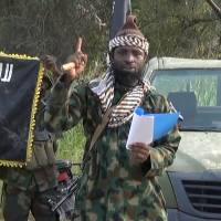 A file picture of a screengrab taken on Oct. 2, 2014, from a video released by the Nigerian Islamist group Boko Haram and obtained by AFP shows Boko Haram leader Abubakar Shekau gesturing as he delivers a speech. The leader of Nigeria\'s Boko Haram denied he had been killed or ousted as chief of the jihadist group in an audio recording released Saturday attributed to him by security experts. Boko Haram is believed to have been behind an attack last week in Nigeria that left 151 people dead, many of whom drowned. | BOKO HARAM / HO / AFP-JIJI