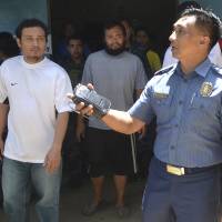 Escaped hostages Philippine coast guard personnel Seaman Second Class (SN2) Gringo Villaruz (left) and Seaman First Class (SN1) Rod Pagaling (center) walk inside a military camp in Jolo, Sulu province, southern Philippines, Thursday. The two, who were threatened with beheading, escaped from their Abu Sayyaf extremist captors when hundreds of troops stormed the militants\' jungle base in the country\'s south, military officials said Thursday. | AP