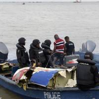 Marine police officers in a boat collect parts recovered from the helicopter, operated by the U.S.-based Bristow Group that crashed into a lagoon at the Oworonshoki district of Lagos on Wednesday. At least four people were killed and six wounded when the helicopter plunged into a lagoon in Nigeria\'s commercial hub Lagos. The helicopter came down behind a police station in the Oworonshoki area in the city\'s north, according to the National Emergency Management Agency. Two people were still missing. | AFP-JIJI