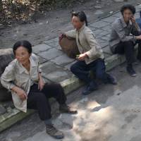 Street vendors sit on a sidewalk in Samjiyon County, Ryanggang province, North Korea, in September 2010. | REUTERS