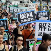 Hundreds of student protesters demonstrate against changes to their curriculum during a march near the Ministry of Education in Taipei on Sunday. Dozens of students stormed the ministry Friday, demanding that officials take responsibility for a student leader who killed himself in an apparent protest over curriculum changes that critics say overemphasize China\'s ties to the island. | AP