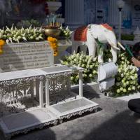 A man prays Tuesday near the Erawan Shrine the morning after an explosion in Bangkok. A bomb exploded Monday within a central Bangkok shrine that is among the city\'s most popular tourist spots, killing a number of people and injuring others, police said. | AP