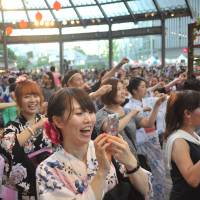 Visitors crowd around a central stage to watch Bon dancing presented at the annual Roppongi Hills Bon Odori festival on Saturday. | KAZUAKI NAGATA