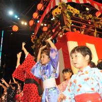 Young children enjoy taking part in the Bon Odori festival at Roppongi Hills, in central Tokyo, on Saturday. | KAZUAKI NAGATA
