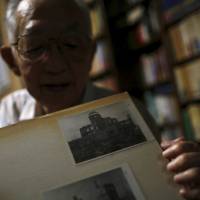 Hiroshima A-bomb survivor Akira Yamada, 89, shows a photo of the Atomic Bomb Dome during an interview in Fukushima on July 30. Yamada heads a group of survivors in the prefecture. | REUTERS