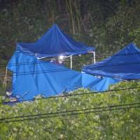 Investigators probe the area in which the body of Ryoto Hoshino was found in Kashiwara, Osaka Prefecture, at 9:47 p.m. on Friday. | KYODO
